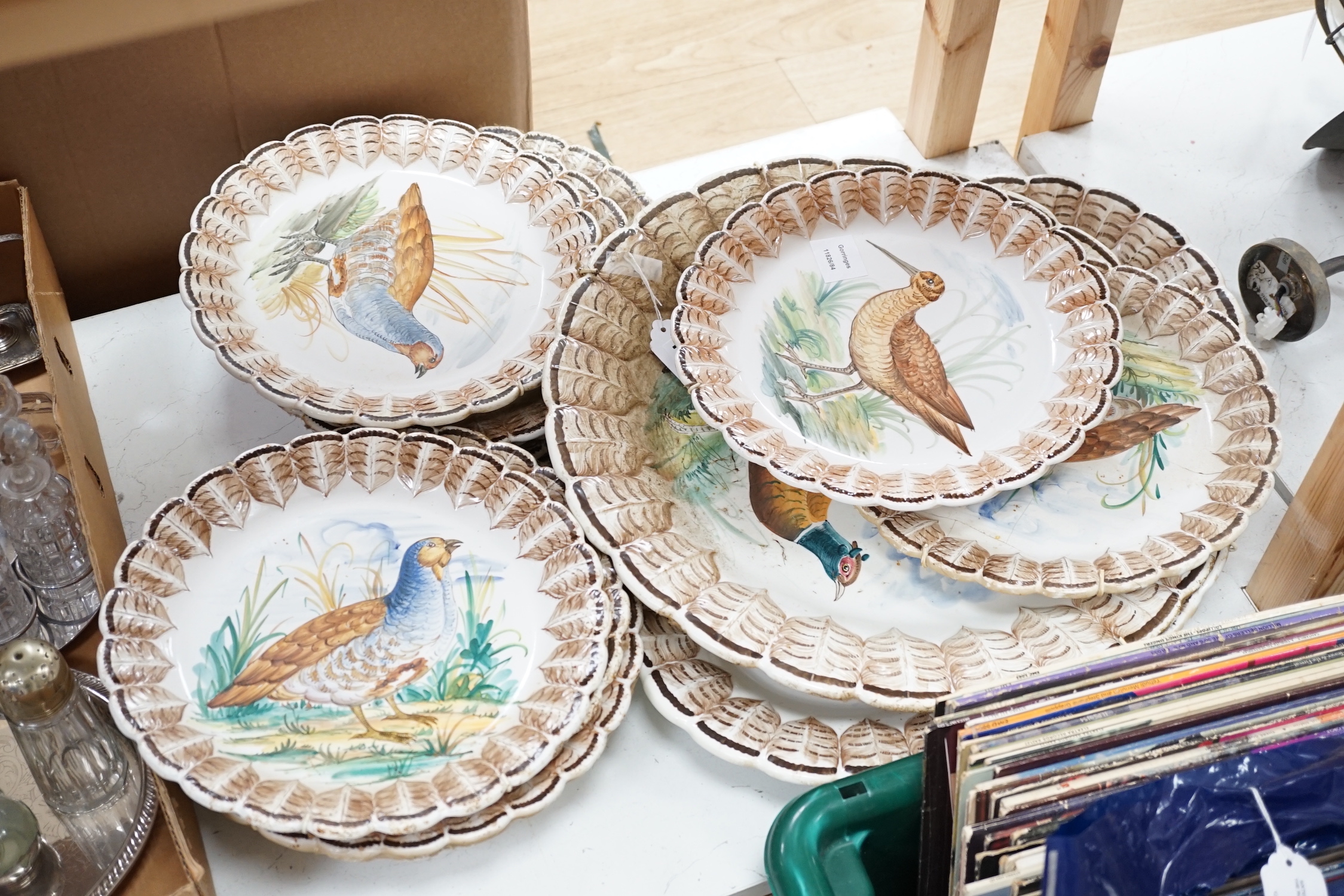 A set of Italian maiolica plates and serving dishes painted with central bird decoration within a painted feather border